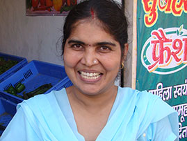 Woman in India smiling in front of shop